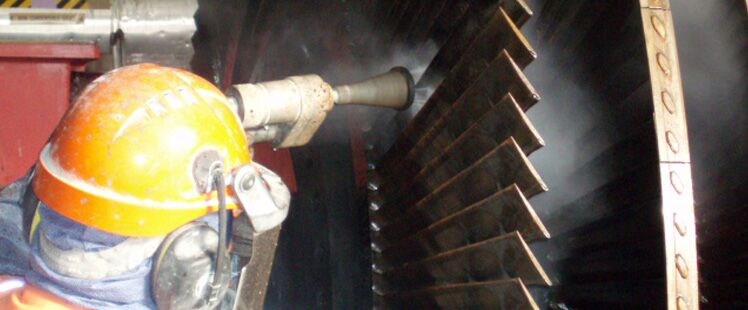 An operator lancing between turbine blades inside a geothermal plant
